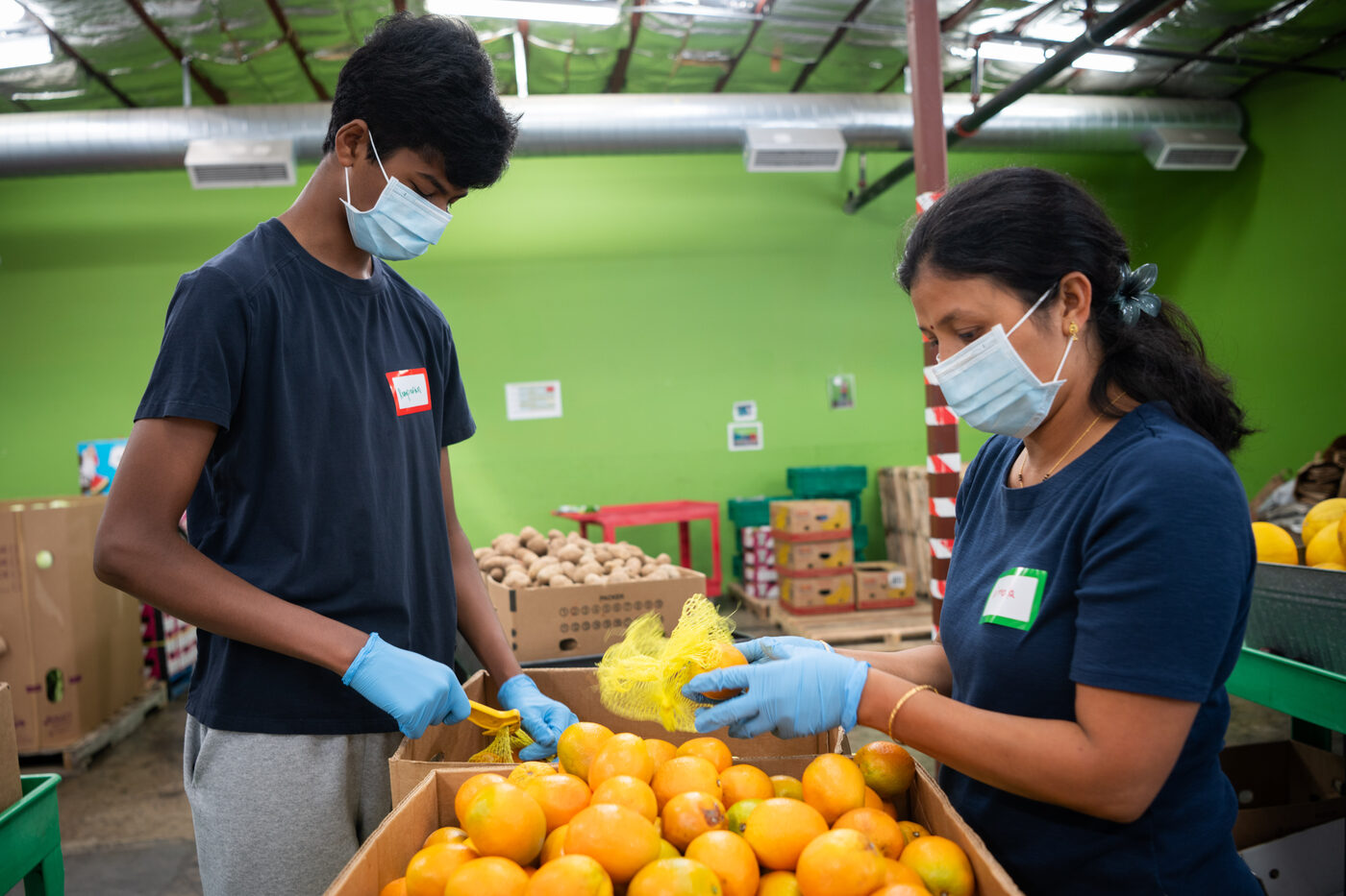 TCV volunteers sorting fresh oranges for neighbors in need